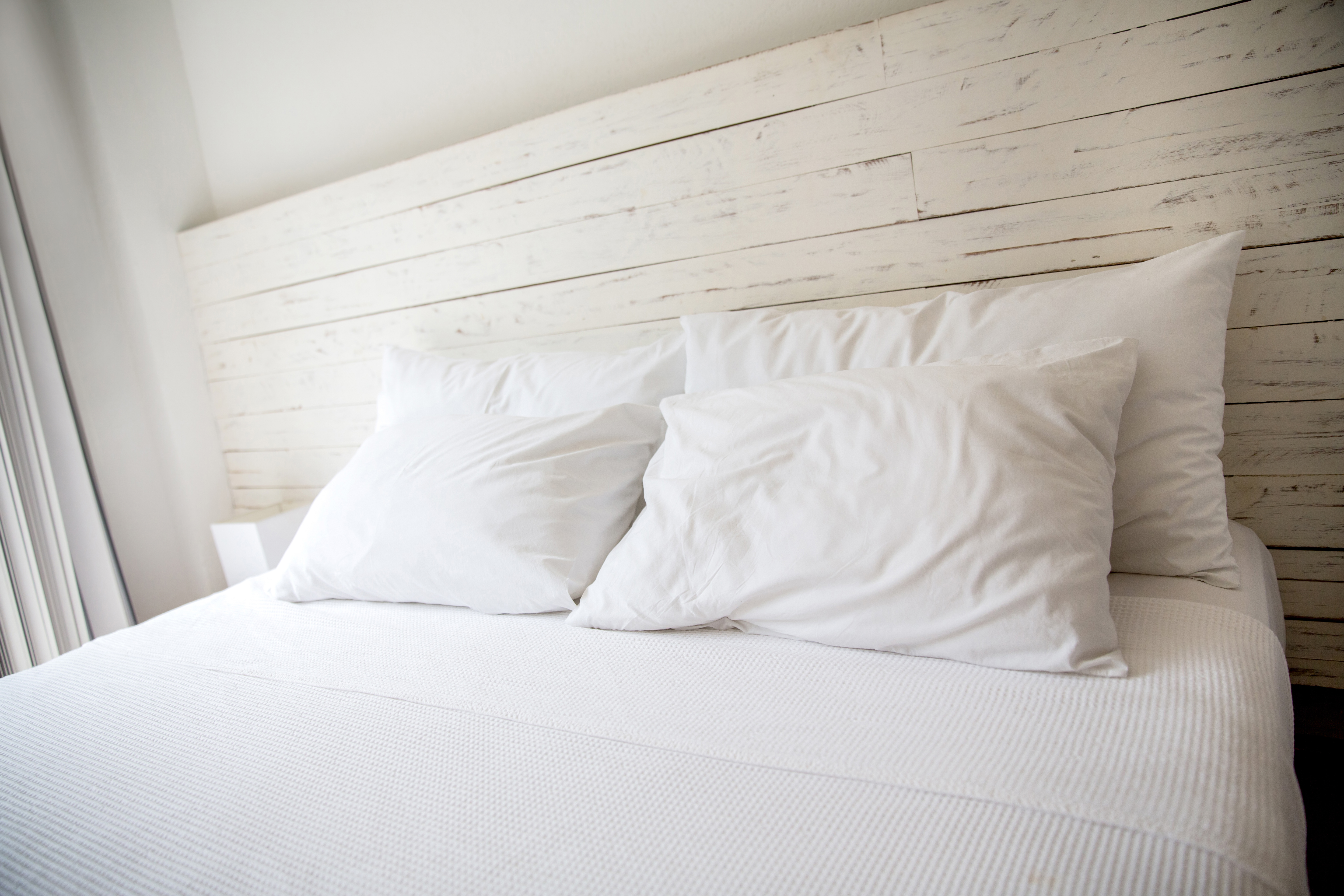 White bedroom with a king size bed and pillows